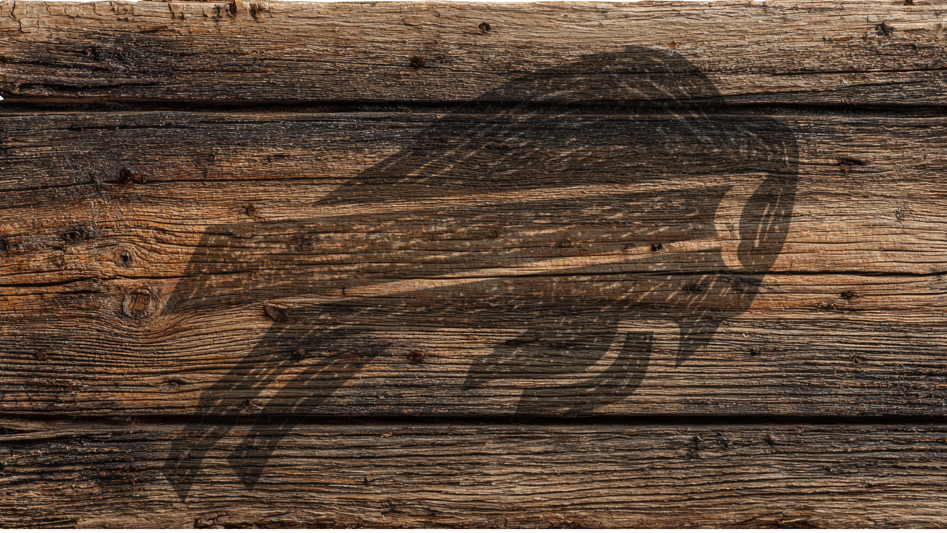 A rustic dark brown wood plank surface with a large black engraved or burned graphic of a bird, likely a hawk or eagle, across the center.